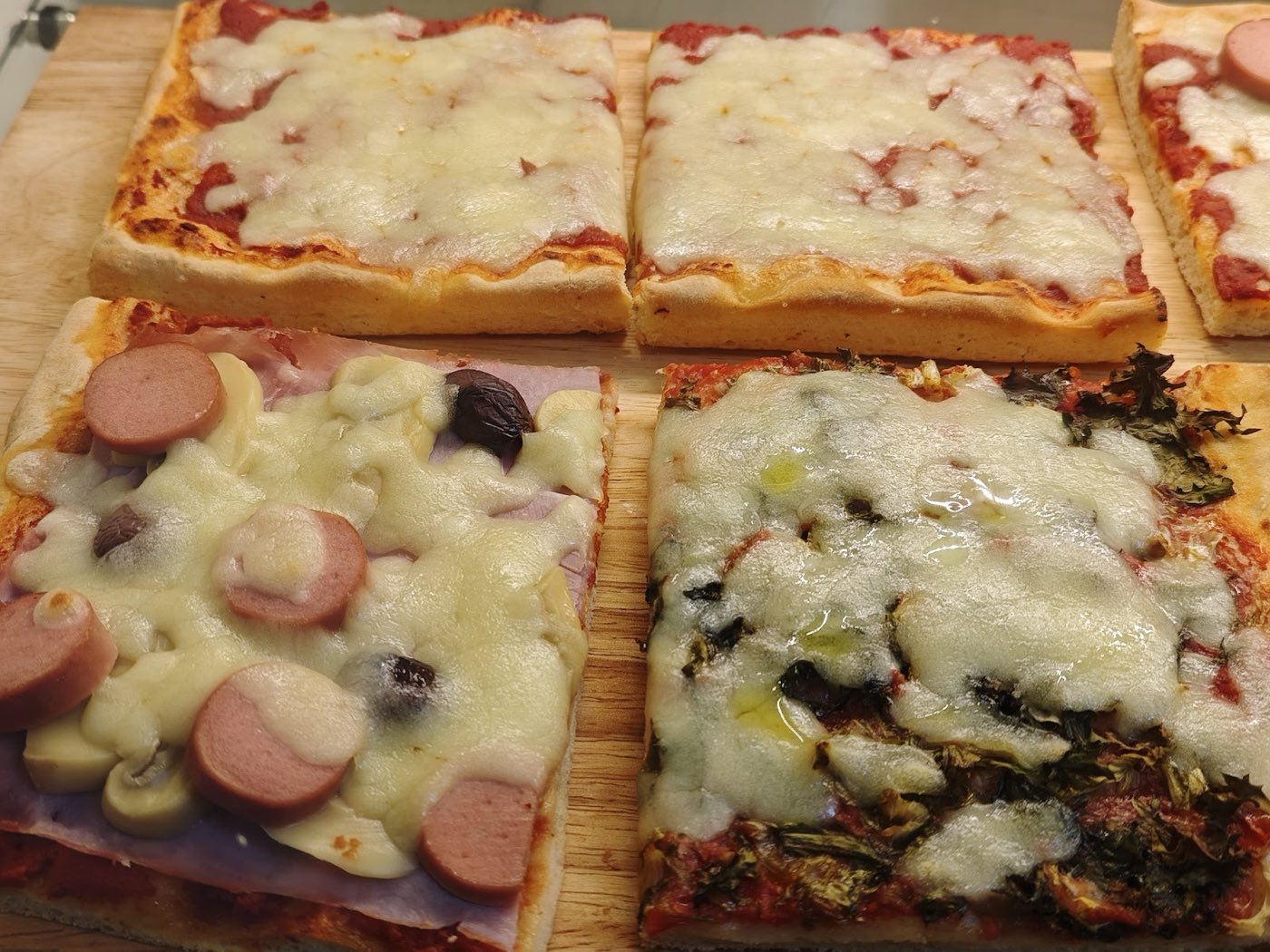 Focaccia al taglio tagliata a tranci su un tagliere di legno