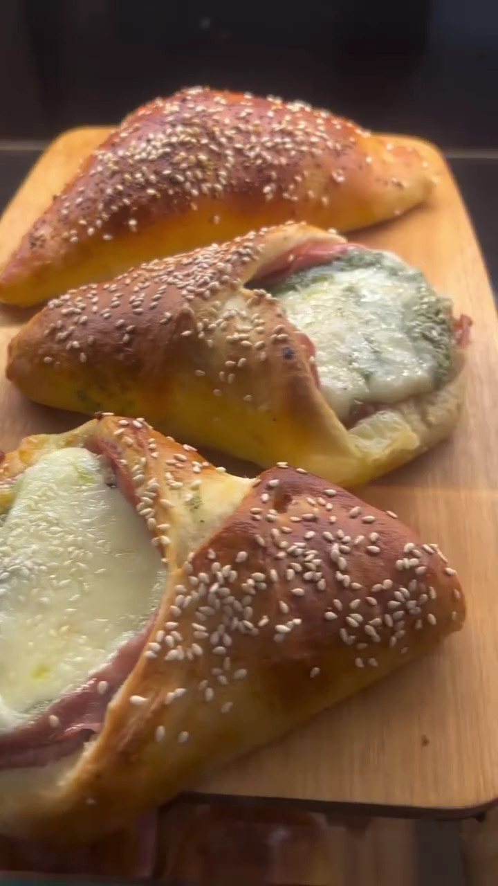 Calzoni caldi con crosta di sesamo, farciti con prosciutto e mozzarella